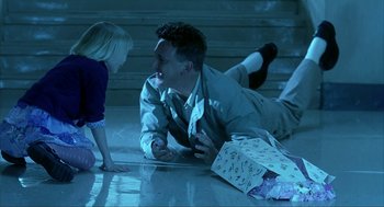 Movie still from “I Am Sam” (2001), directed by Jessie Nelson – A man laying on the ground next to a little girl; Medium shot, High angle