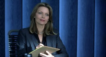 Movie still from “I Am Sam” (2001), directed by Jessie Nelson – A woman in a black jacket holding a notepad and pen; Close Up shot, Over the shoulder angle