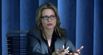 Movie still from “I Am Sam” (2001), directed by Jessie Nelson – A woman in a business suit is sitting in front of a blue wall; Close Up shot, Over the shoulder angle