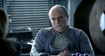 Movie still from “I Am Sam” (2001), directed by Jessie Nelson – A man sitting at a table in front of a window; Close Up shot, Over the shoulder angle