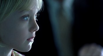 Movie still from “I Am Sam” (2001), directed by Jessie Nelson – A young woman looking into the distance in a dimly - lit room; Close Up shot, Over the shoulder angle