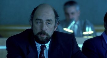 Movie still from “I Am Sam” (2001), directed by Jessie Nelson – A man in a suit and tie sitting in front of a mirror; Close Up shot, Over the shoulder angle