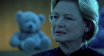 Movie still from “I Am Sam” (2001), directed by Jessie Nelson – An older woman with a teddy bear in the background; Close Up shot, Over the shoulder angle