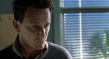 Movie still from “I Am Sam” (2001), directed by Jessie Nelson – A person wearing a sweater near a window; Close Up shot, Low angle