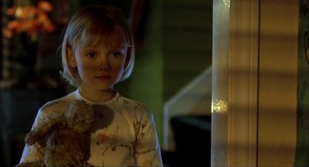 Movie still from “I Am Sam” (2001), directed by Jessie Nelson – A little girl standing next to a window with a teddy bear; Close Up shot, Over the shoulder angle