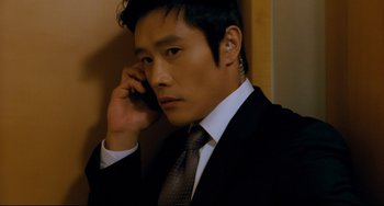 Movie still from “I Saw the Devil” (2010), directed by Jee-woon Kim – A man in a suit and tie talking on a cell phone; Close Up shot, Over the shoulder angle