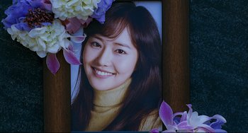 Movie still from “I Saw the Devil” (2010), directed by Jee-woon Kim – A picture of a young woman with flowers around it; Extreme Close Up shot, Overhead angle