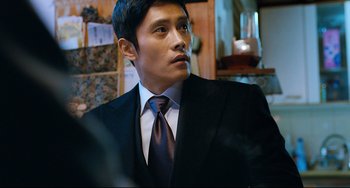 Movie still from “I Saw the Devil” (2010), directed by Jee-woon Kim – A man in a suit and tie looking to his left; Close Up shot, Low angle