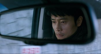 Movie still from “I Saw the Devil” (2010), directed by Jee-woon Kim – A person in a car looking out the window; Close Up shot, Over the shoulder angle