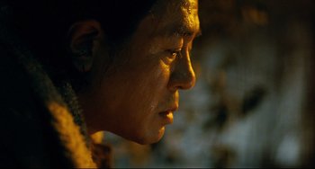 Movie still from “I Saw the Devil” (2010), directed by Jee-woon Kim – A person's face in the dark; Close Up shot, Over the shoulder angle