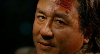 Movie still from “I Saw the Devil” (2010), directed by Jee-woon Kim – A person with a head injury; Close Up shot, Over the shoulder angle