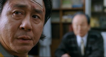 Movie still from “I Saw the Devil” (2010), directed by Jee-woon Kim – A person with a bandage on his head; Close Up shot, Over the shoulder angle