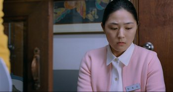 Movie still from “I Saw the Devil” (2010), directed by Jee-woon Kim – A woman in a white shirt and a pink jacket; Medium shot, Over the shoulder angle