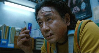 An asian man holding a cigarette in his hand