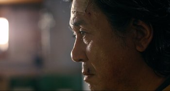 Movie still from “I Saw the Devil” (2010), directed by Jee-woon Kim – A person's face with makeup on; Extreme Close Up shot, Over the shoulder angle