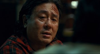 Movie still from “I Saw the Devil” (2010), directed by Jee-woon Kim – A man with a bandage on his head and face; Close Up shot, Over the shoulder angle