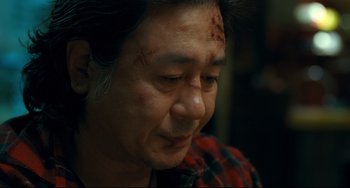 Movie still from “I Saw the Devil” (2010), directed by Jee-woon Kim – A person with a bruise on his face; Close Up shot, Over the shoulder angle