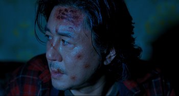 Movie still from “I Saw the Devil” (2010), directed by Jee-woon Kim – A person with blood on his face; Close Up shot, High angle