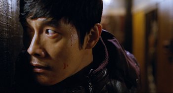 Movie still from “I Saw the Devil” (2010), directed by Jee-woon Kim – A person wearing a leather jacket; Close Up shot, Over the shoulder angle
