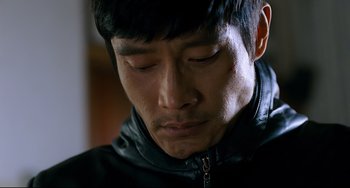 Movie still from “I Saw the Devil” (2010), directed by Jee-woon Kim – A person wearing a jacket looking down; Close Up shot, High angle