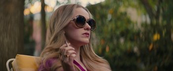 Movie still from “I'm Your Woman” (2020), directed by Julia Hart – A woman with long blonde hair wearing sunglasses and holding a cell phone to her ear; Close Up shot, Low angle