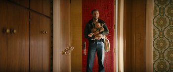 Movie still from “I'm Your Woman” (2020), directed by Julia Hart – A man standing in front of a door holding a baby; Medium shot, Low angle