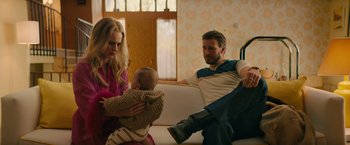 Movie still from “I'm Your Woman” (2020), directed by Julia Hart – A man and a woman are holding a baby; Medium shot, High angle