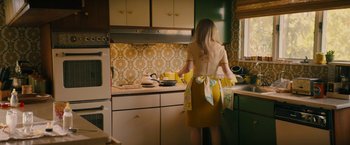 Movie still from “I'm Your Woman” (2020), directed by Julia Hart – A woman standing in a kitchen preparing a meal; Medium shot, High angle