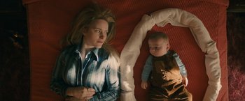 Movie still from “I'm Your Woman” (2020), directed by Julia Hart – A woman and a baby laying on a bed; Medium shot, Overhead angle
