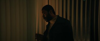Movie still from “I'm Your Woman” (2020), directed by Julia Hart – A man standing next to a window in a dark room; Medium shot, Low angle