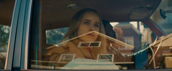Movie still from “I'm Your Woman” (2020), directed by Julia Hart – A woman sitting in the back seat of a car looking out of the window; Close Up shot, Low angle
