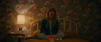 Movie still from “I'm Your Woman” (2020), directed by Julia Hart – A woman sitting on a bed next to an alarm clock; Medium shot, High angle