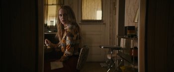 Movie still from “I'm Your Woman” (2020), directed by Julia Hart – A woman sitting at a dining room table; Medium shot, Over the shoulder angle