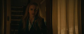 Movie still from “I'm Your Woman” (2020), directed by Julia Hart – A woman standing in front of a window in the dark; Medium shot, Over the shoulder angle
