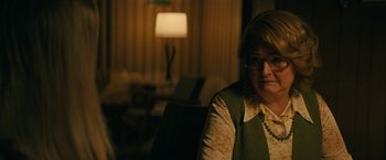 Movie still from “I'm Your Woman” (2020), directed by Julia Hart – A woman sitting in front of a lamp in a living room; Close Up shot, Over the shoulder angle