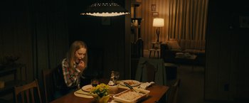Movie still from “I'm Your Woman” (2020), directed by Julia Hart – A little girl sitting at a dinner table eating pizza; Medium shot, Over the shoulder angle
