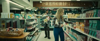 Movie still from “I'm Your Woman” (2020), directed by Julia Hart – A man and a woman shopping in a pharmacy; Medium shot, Low angle