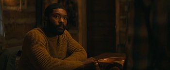 Movie still from “I'm Your Woman” (2020), directed by Julia Hart – A man sitting at a table with a bowl in front of him; Medium shot, High angle