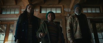 Movie still from “I'm Your Woman” (2020), directed by Julia Hart – A young boy wearing a green hat standing next to two other people; Medium shot, Low angle
