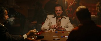 Movie still from “I'm Your Woman” (2020), directed by Julia Hart – A man sitting at a table with a cell phone in front of him; Medium shot, Over the shoulder angle