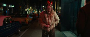 Movie still from “I'm Your Woman” (2020), directed by Julia Hart – A woman wearing a fur coat standing on the sidewalk; Medium shot, High angle