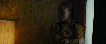 Movie still from “I'm Your Woman” (2020), directed by Julia Hart – A woman with a long dreadlocks wearing a head scarf; Close Up shot, Over the shoulder angle