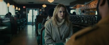 Movie still from “I'm Your Woman” (2020), directed by Julia Hart – A woman sitting at a table with a cup of coffee in front of her; Medium shot, Over the shoulder angle