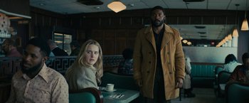 Movie still from “I'm Your Woman” (2020), directed by Julia Hart – A man and a woman standing at a table in a restaurant; Medium shot, Over the shoulder angle