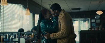 Movie still from “I'm Your Woman” (2020), directed by Julia Hart – A man and a woman are kissing in a restaurant; Medium shot, Low angle