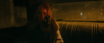 Movie still from “I'm Your Woman” (2020), directed by Julia Hart – A woman holding a gun while sitting in a car; Close Up shot, Low angle