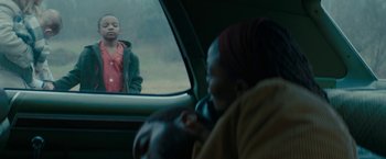 Movie still from “I'm Your Woman” (2020), directed by Julia Hart – Two people sitting in a car looking out the window; Medium shot, Over the shoulder angle