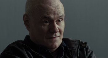 Movie still from “I, Daniel Blake” (2016), directed by Ken Loach – An older bald man with a goatee looking at the camera; Close Up shot, Over the shoulder angle