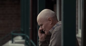 Movie still from “I, Daniel Blake” (2016), directed by Ken Loach – A bald man is talking on a cell phone; Close Up shot, Over the shoulder angle