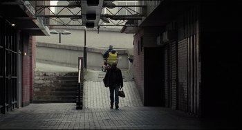 Movie still from “I, Daniel Blake” (2016), directed by Ken Loach – A man walking down a street with a skateboard; Extreme Wide shot, Low angle